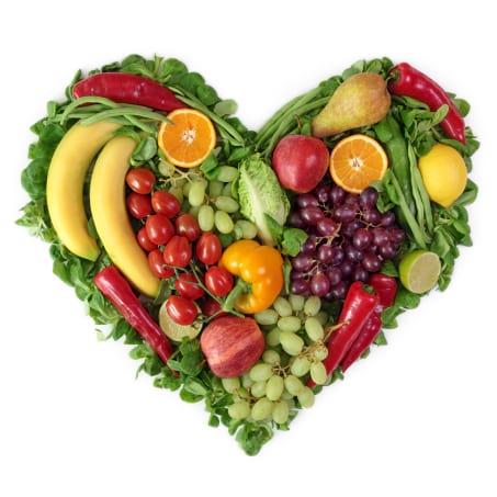 A heart shaped arrangement of fruits and vegetables.