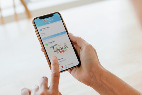 A woman is holding a phone with a logo on it.